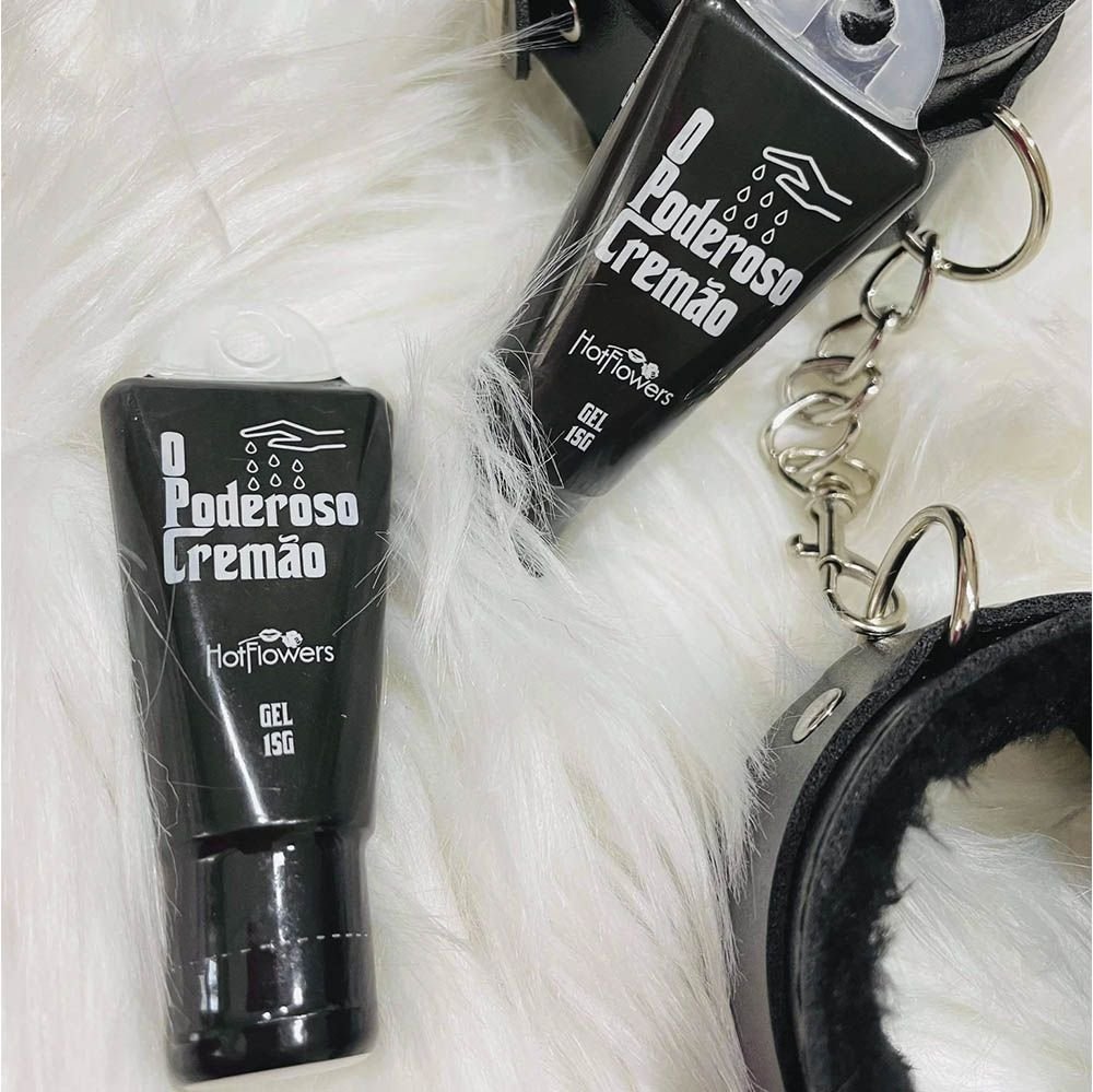Excitante Unissex O Poderoso Crem�o 15ml - Duas embalagens do produto ao lado de algemas de aco e pel�cia, em fundo de pel�cia branca
