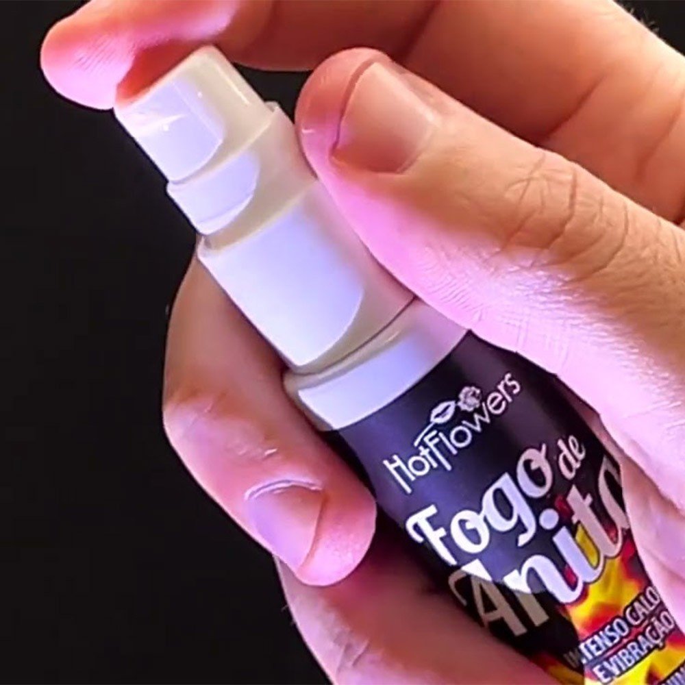 M�o segurando e aplicando o Gel Fogo de Anita, destacando o bico pulverizador e o formato do frasco