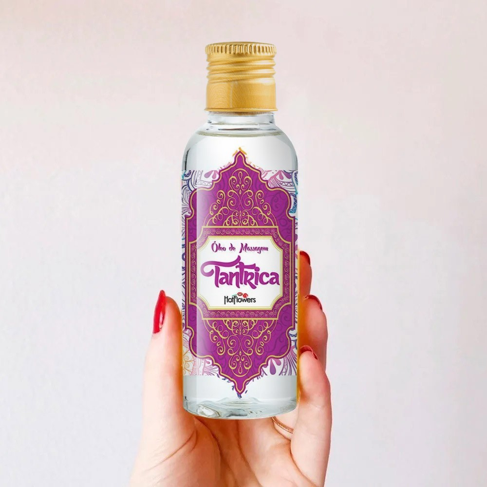 Frasco de �leo para Massagem Sensual T�ntrica Vegano 120ml na m�o de uma pessoa, com unhas vermelhas, fundo claro