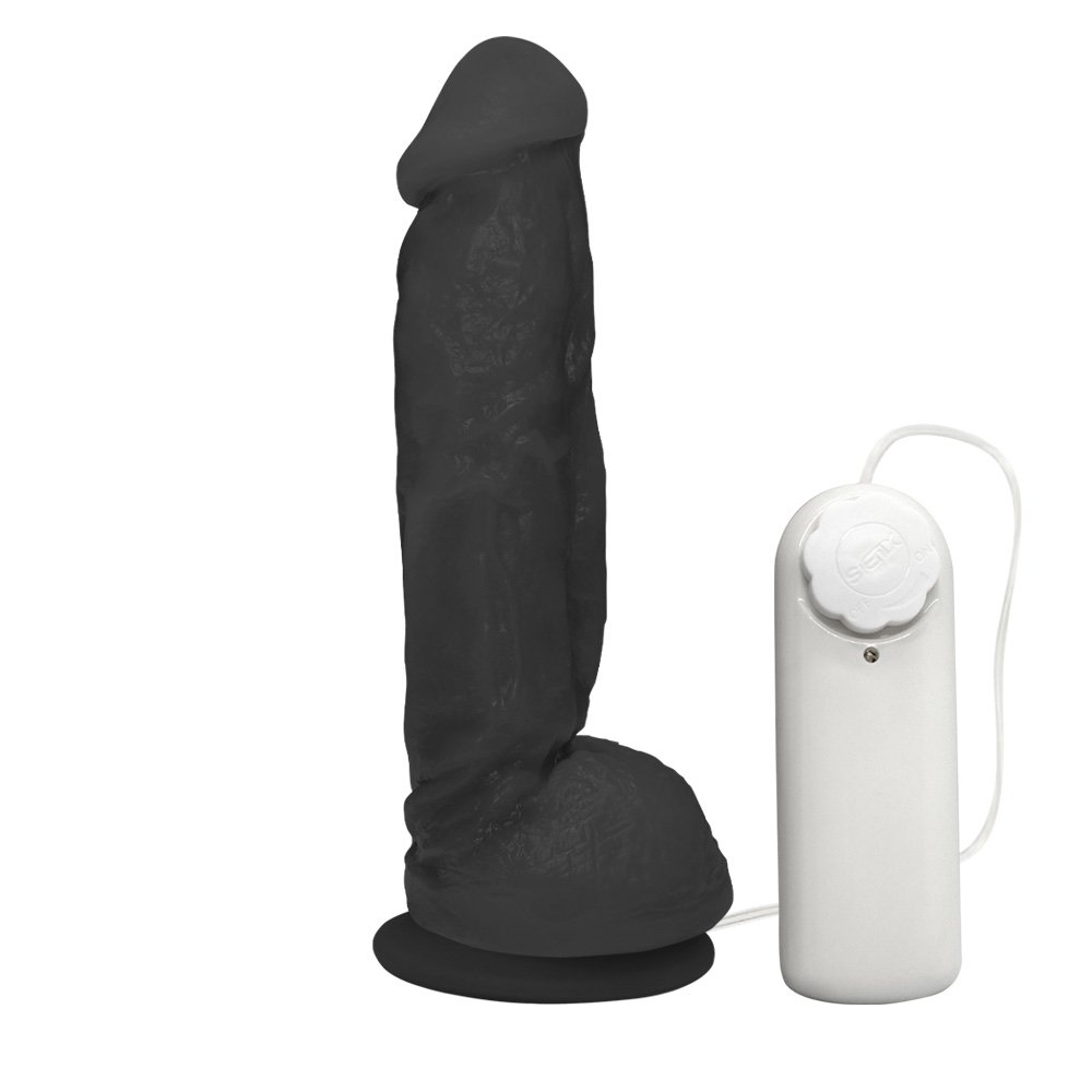 Vista lateral do P�nis Real�stico Feito em PVC Flex�vel com Escroto, Vibrador e Ventosa King 19 x 5cm Preto evidenciando espessura, curvatura e propor��o do produto, com o controle de vibra��o ao lado