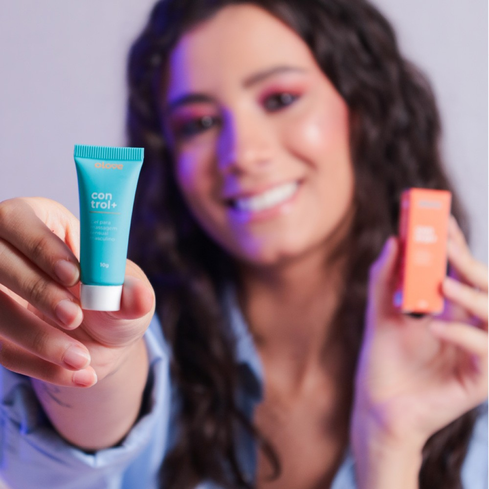 Mulher sorrindo segurando o tubo do Gel Retardante Control+ 10g.