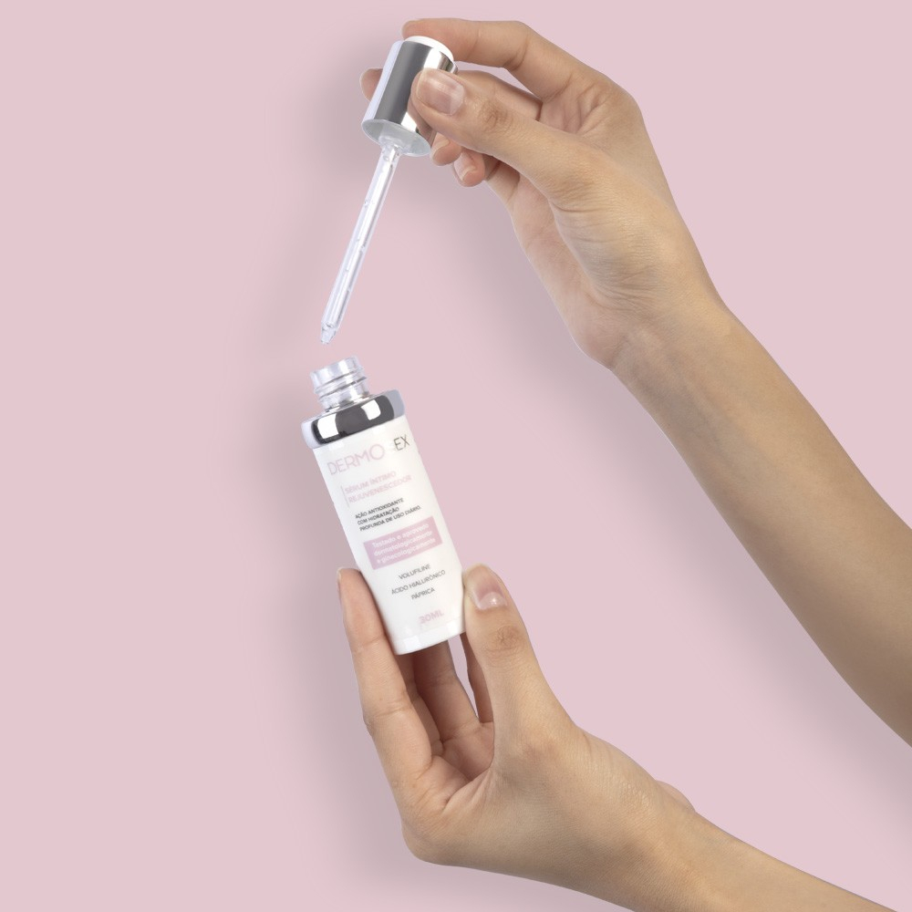 Duas m�os segurando o frasco do S�rum �ntimo Rejuvenescedor com o conta-gotas aberto
