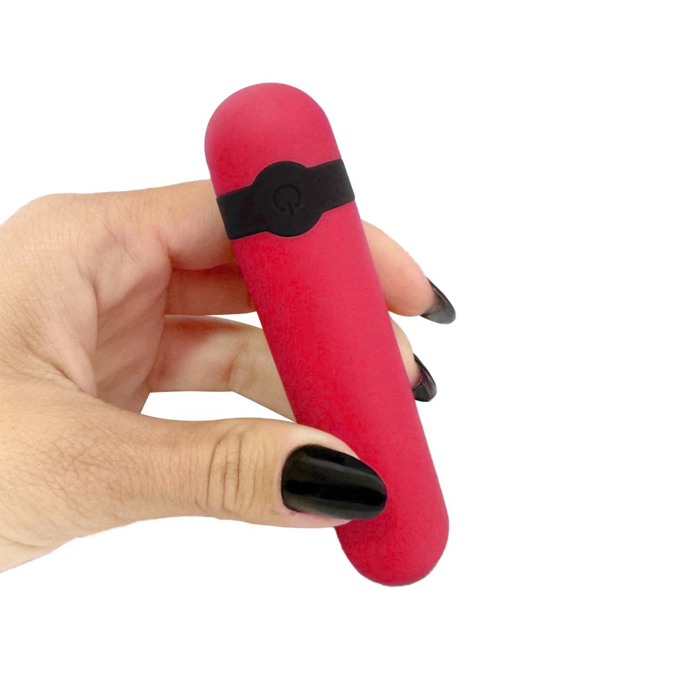 Vibrador Bullet Recarreg�vel Vinho sendo segurado por uma m�o, exibindo seu tamanho compacto e cor