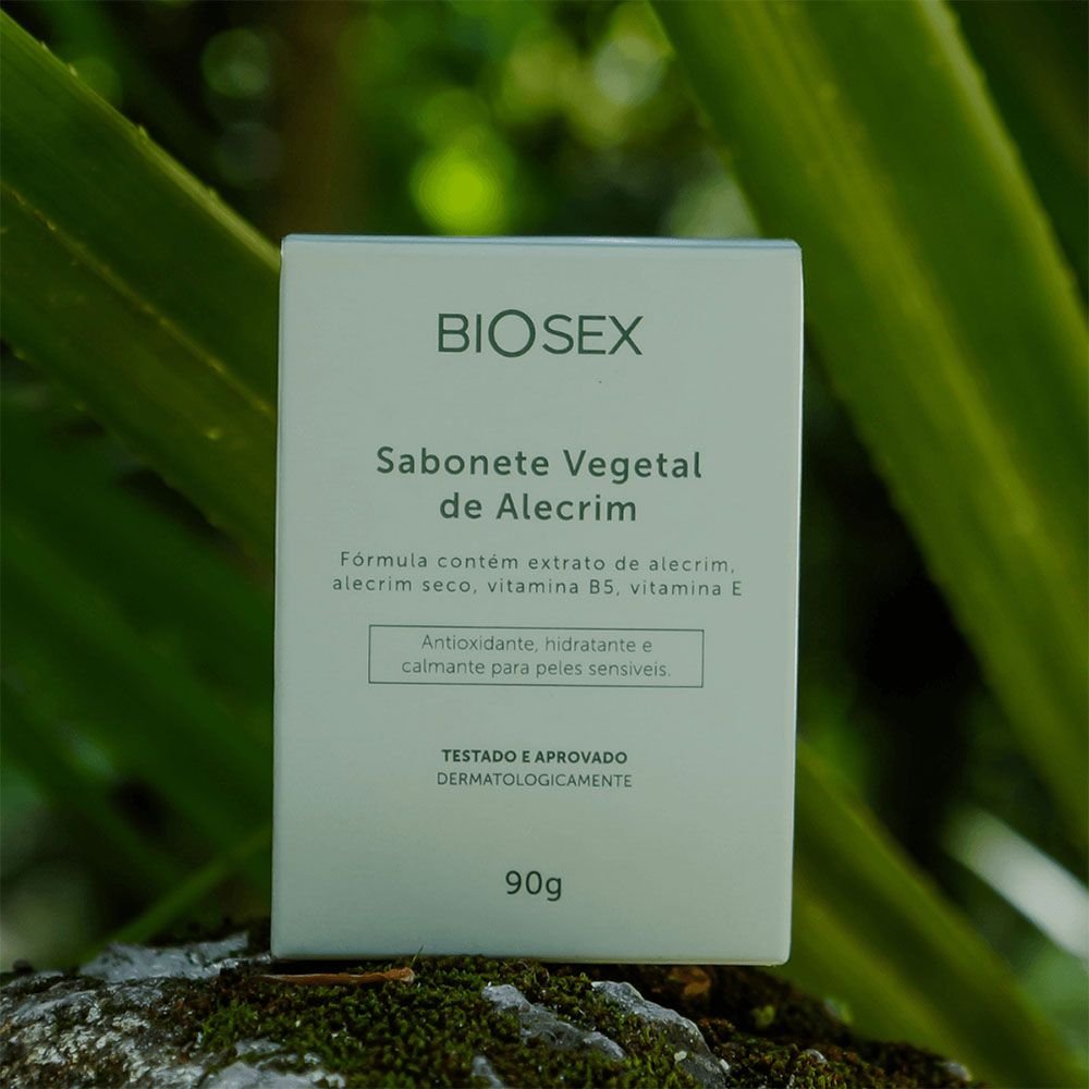 Sabonete �ntimo em Barra de Alecrim Biosex em sua embalagem ecol�gica, posicionada em ambiente natural com folhagem verde e fundo rochoso, destacando a conex�o do produto com a natureza e seus ingredientes naturais.