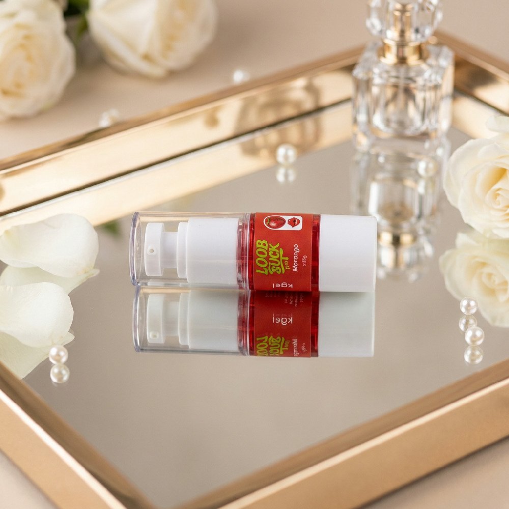 Frasco do Gel Vibrador L�quido Beij�vel LoobSuck Aroma de Morango 19ml deitado sobre um espelho com rosas.