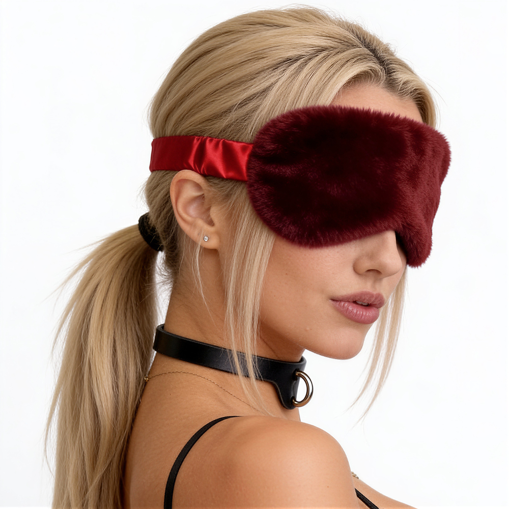 Vista lateral da venda de pel�cia vinho no rosto de uma mulher loira, com el�stico de cetim vis�vel e gola BDSM