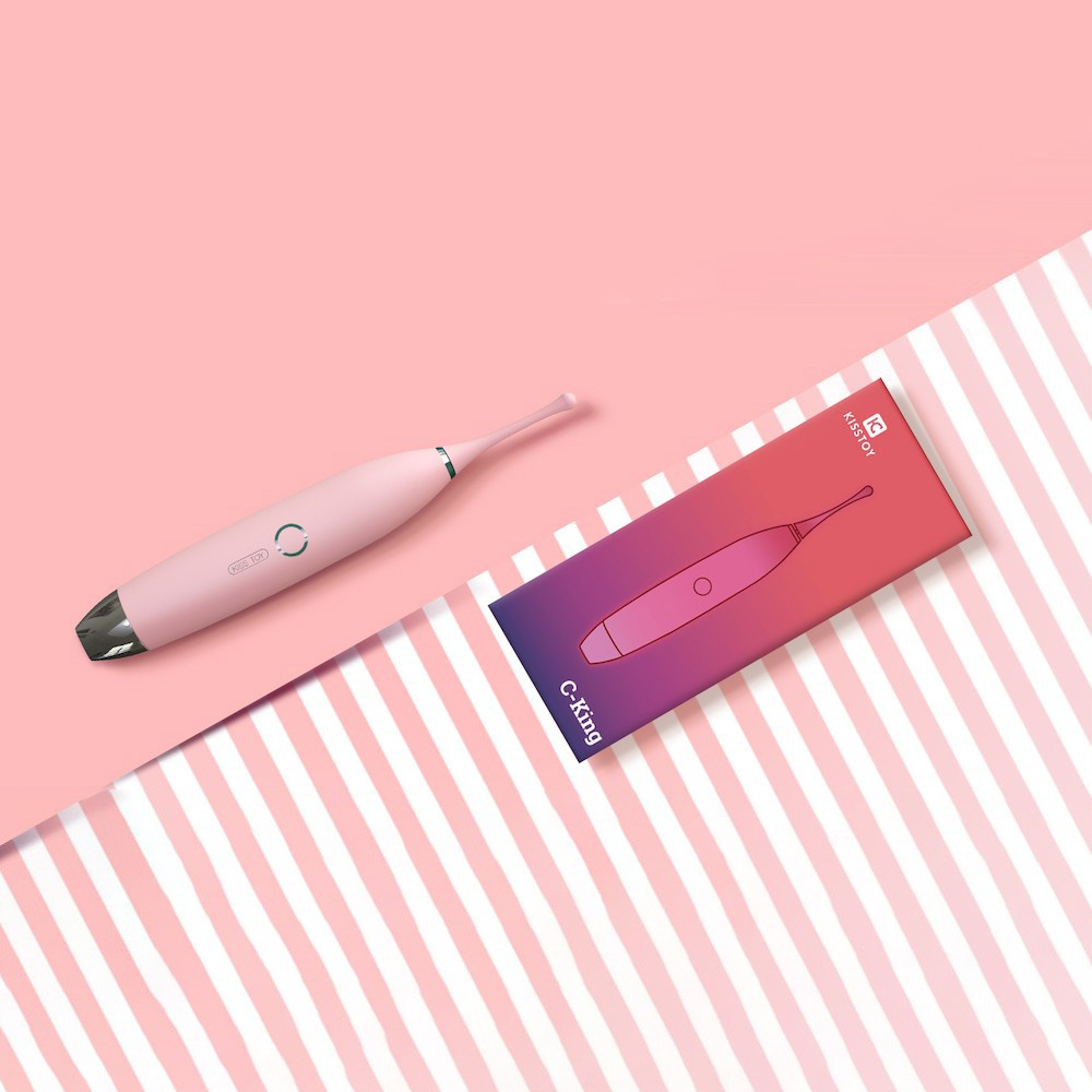 Vibrador Feminino C-King Rosa e sua caixa de embalagem sobre um fundo com listras rosas, com o vibrador deitado