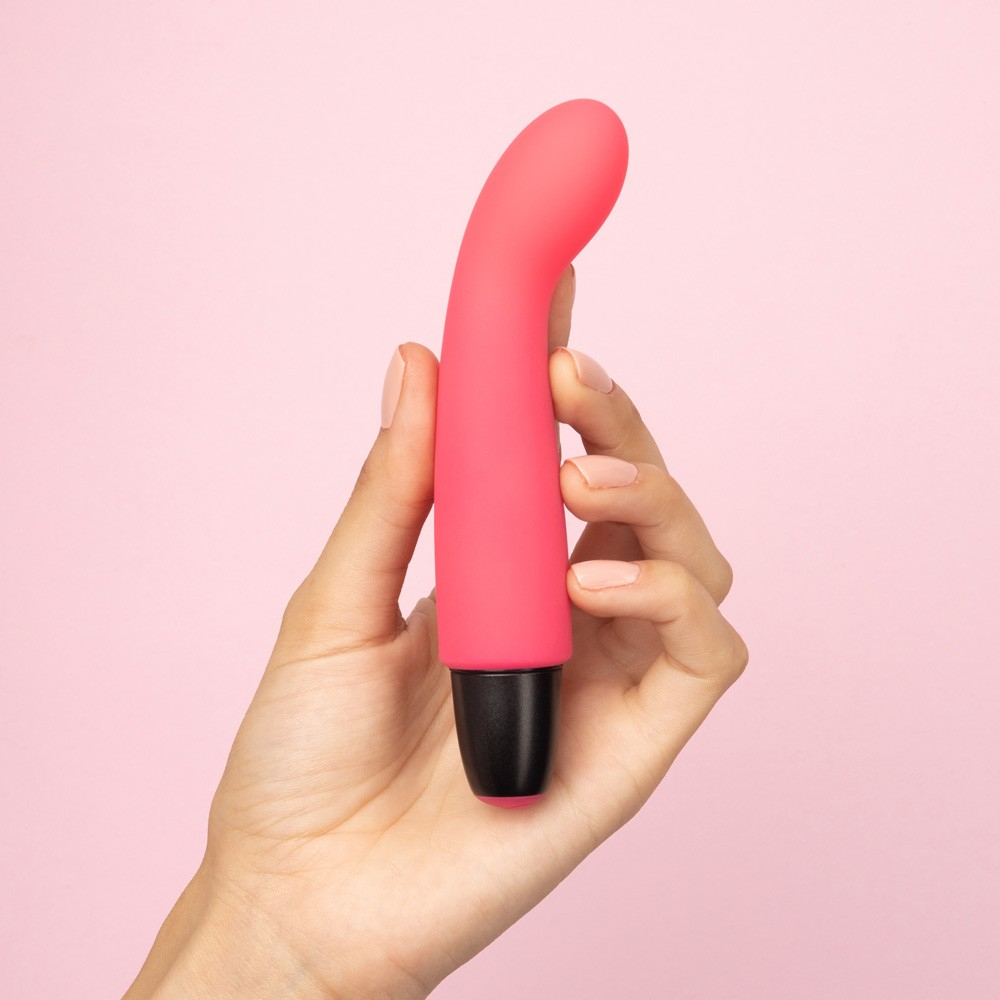 Vibrador Ponto G Recarreg�vel em Silicone com 10 Vibra��es Gvibe Pink sendo segurado por uma m�o