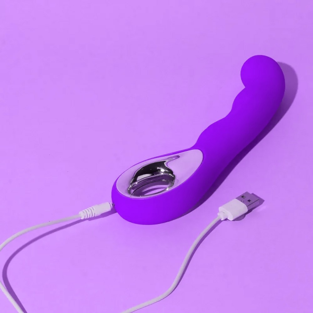 Vibrador Ponto G Recarreg�vel em Silicone Roxo sendo carregado via USB, com o cabo conectado