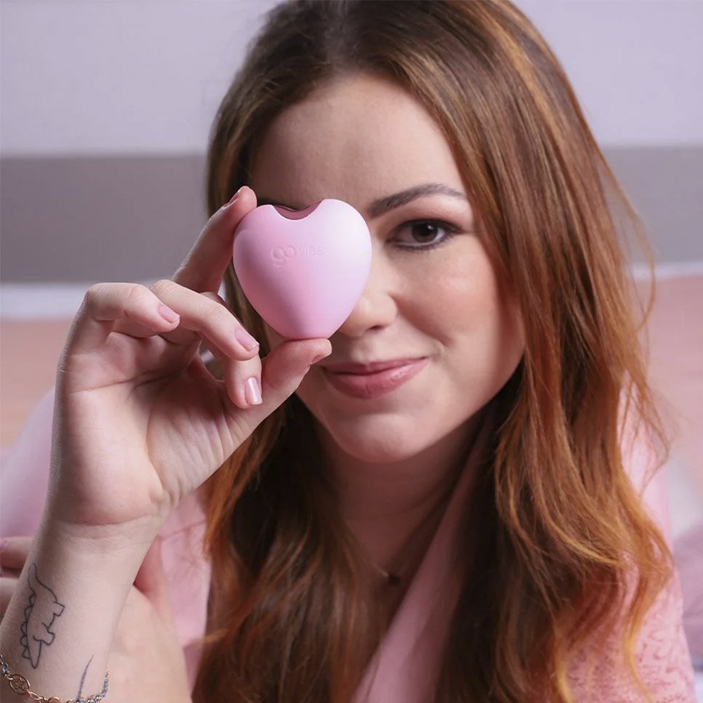 Modelo segurando o Vibrador para Clit�ris Recarreg�vel em Silicone Love Rosa mostrando o tamanho e formato