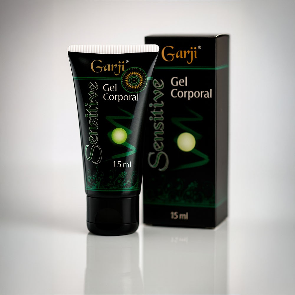Gel para Sexo Anal Sensitive 15g Garji, embalagem em tubo preto com detalhes verdes e dourados, ao lado da caixa, em fundo cinza