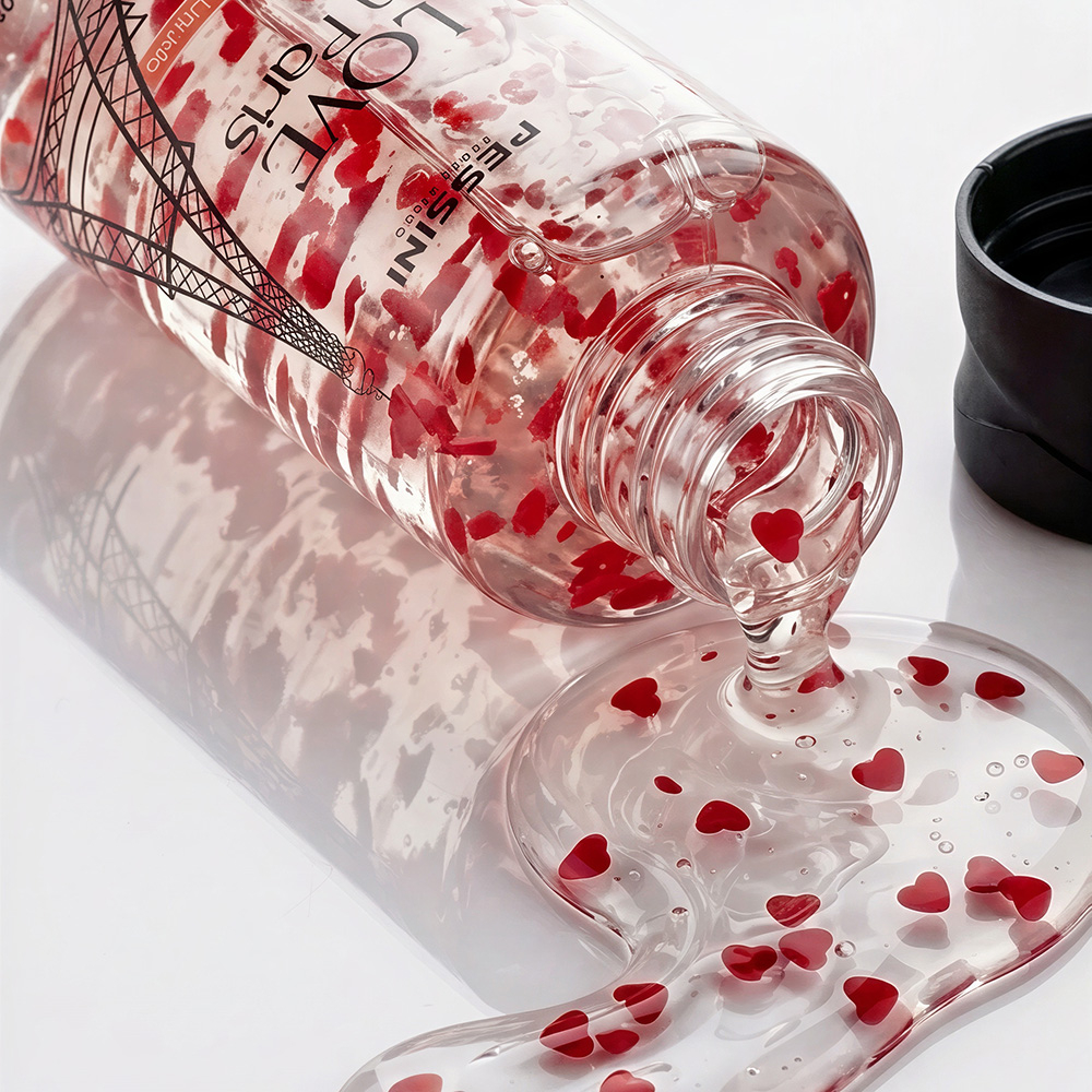 Sabonete Corporal L�quido Love In Paris derramado mostrando a textura em gel transparente e as c�psulas esfoliantes em formato de cora��o vermelho