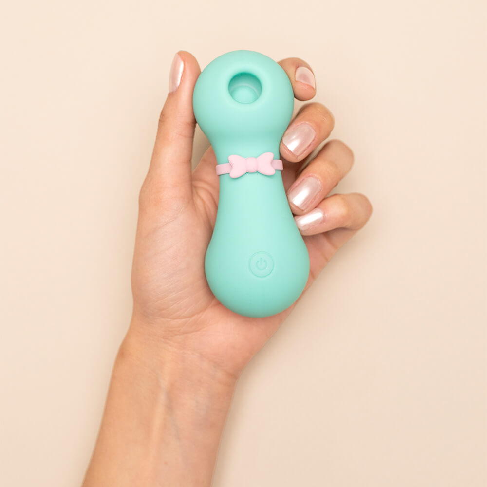 Vibrador Jack Cyan sendo segurado por uma m�o feminina, destacando seu tamanho compacto