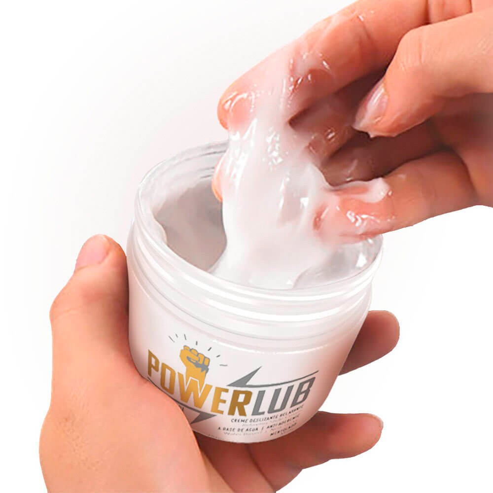 M�os aplicando o Lubrificante PowerLub para Fisting com �leo Coco 250g nos dedos, destacando a textura espessa e transparente do gel.